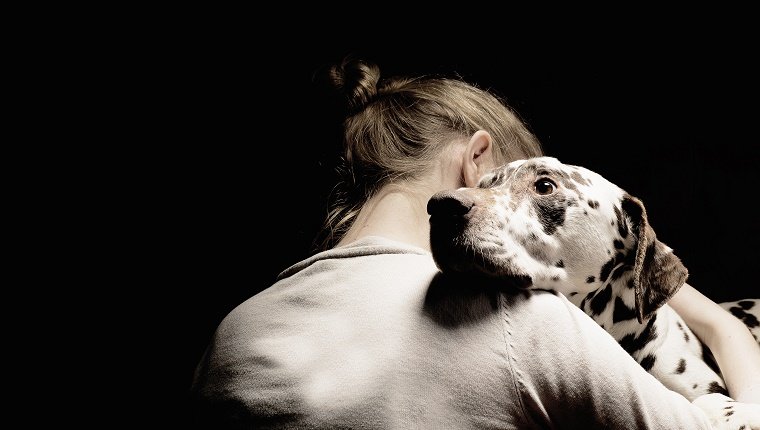 girl embracing her dog, studio shot