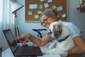 Close up of Caucasian woman and her dog working at home