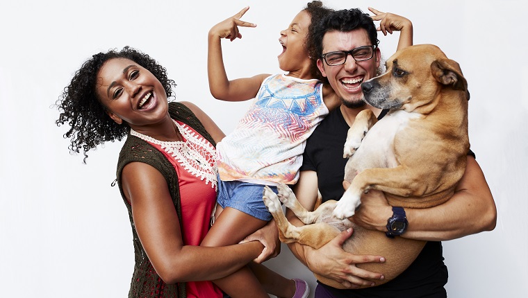 Man and woman holding daughter and dog