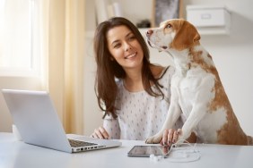 Woman playing with dog at home office