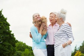 Senior women holding dog in park