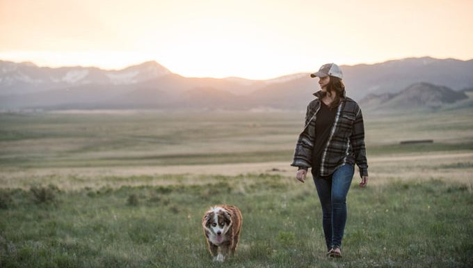 woman walking next to dog