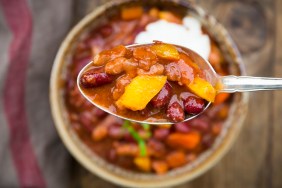 Chili con Carne with coriander and sour cream, spoon, close-up