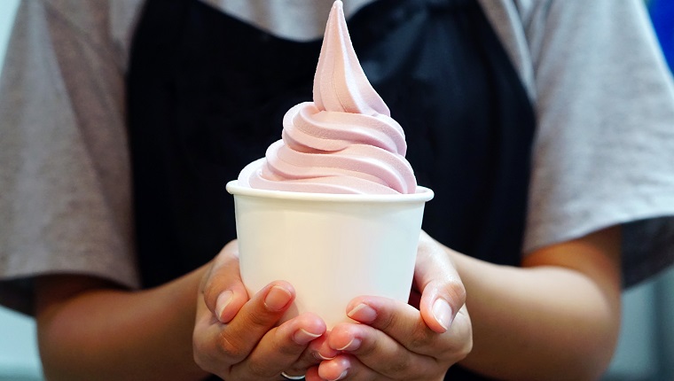 Closeup of woman 's hand holding takeaway cup with organic frozen yogurt ice cream, It's delicious and healthy enjoy eating concept.