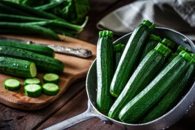 Fresh organic zucchini in an old metal colander shot on rustic wooden table. This vegetable is considered a healthy salad ingredient. Predominant colors are green and brown. Low key DSRL studio photo taken with Canon EOS 5D Mk II and Canon EF 100mm f/2.8L Macro IS USM