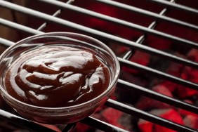 A bowl of BBQ sauce on the grill.