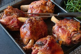 homemade german meal roasted Pork knuckles or pork hock served on a baking tray - ready to eat