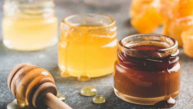 Selection of honey in small honey jars. Closeup view, toned image