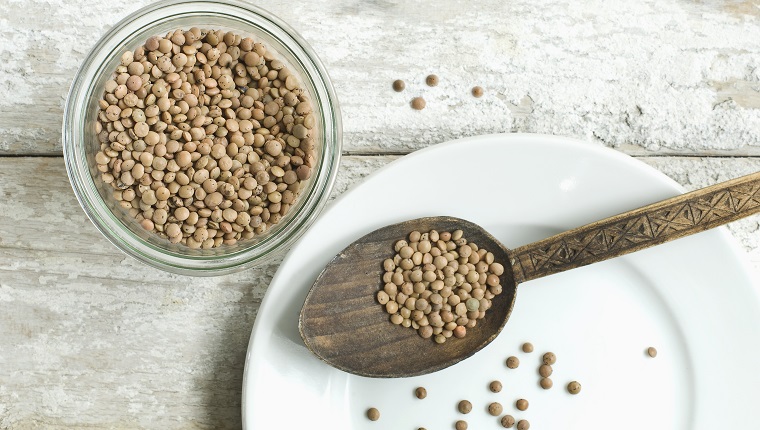 Jar of Mountain lentils on wooden table seen from above