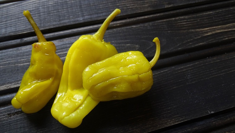 Pepperoncini peppers on a rustic, wooden background.