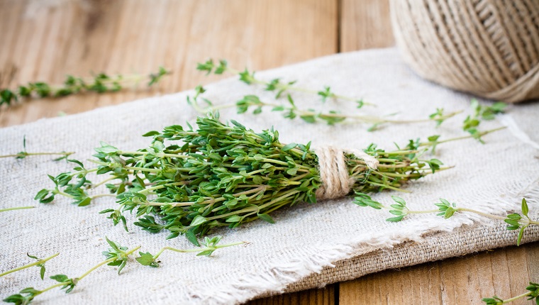 bundle of raw fresh organic thyme on sackcloth