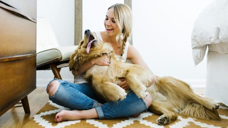 woman hugging golden retriever best dog breeds for an aquarius