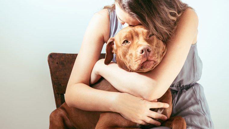 sad woman hugging dog why people surrender dogs