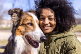 happy woman with dog keeping dog safe from pet thieves