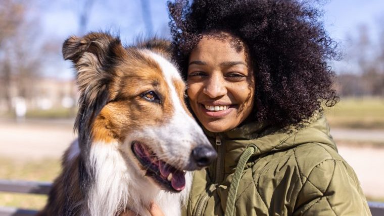 happy woman with dog keeping dog safe from pet thieves