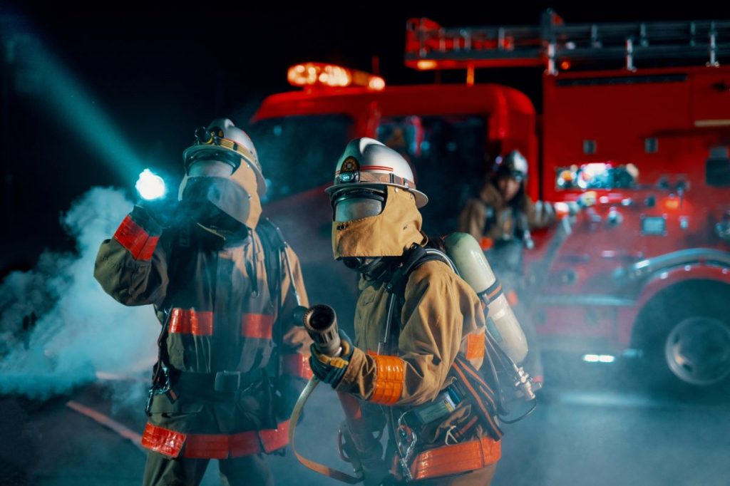 Firefighters shining a searchlight as they battle a fire. Dog Killed Following Fire at Seattle Dog Daycare.