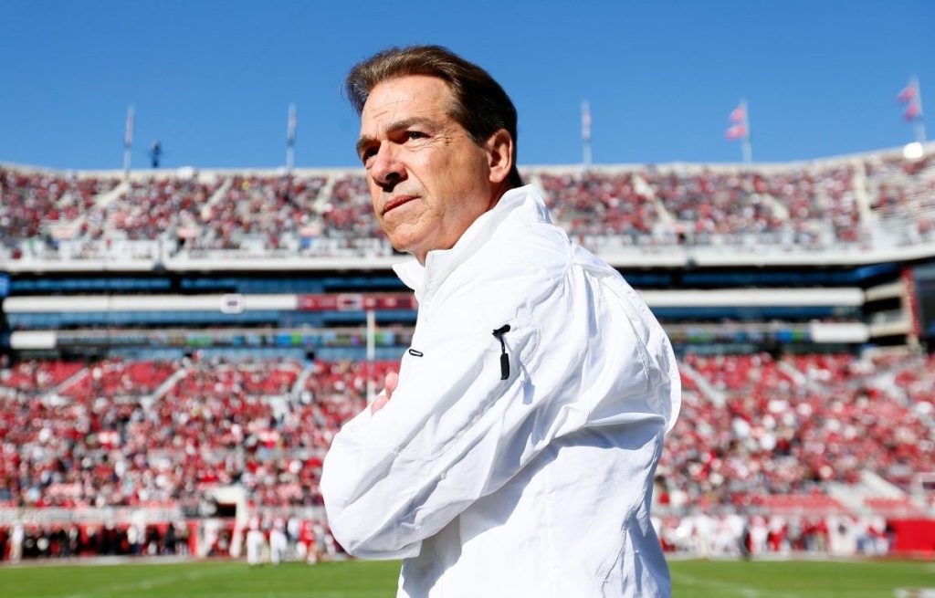 Nick Saban retiring. An image of Saban in a white shirt in a full stadium of Alabama fans.