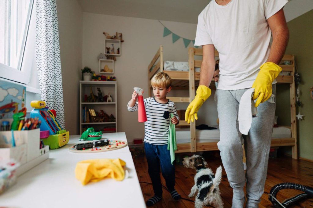 Dad and son cleaning the room with pet-safe cleaning products.