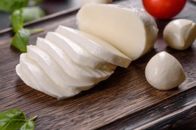 A closeup photo of sliced mozzarella cheese, which can be safe for dogs in moderation.