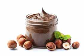 Chocolate with hazelnuts splash with hazelnuts on white backgrounds.