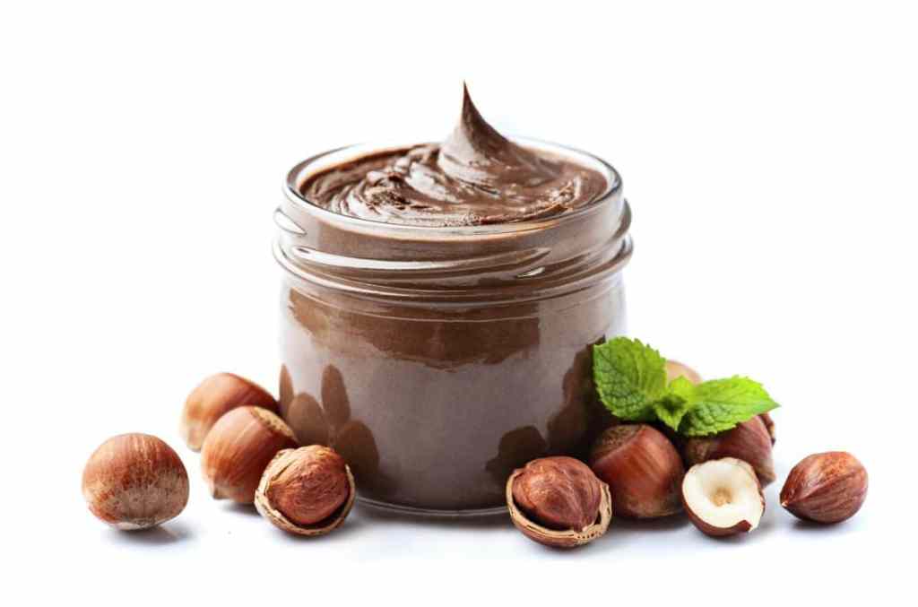 Chocolate with hazelnuts splash with hazelnuts on white backgrounds.