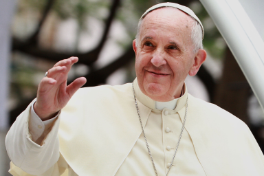 Pope Francis waves to thousands of followers as he arrives at the Manila Cathedral on January 16, 2015 in Manila, Philippines.