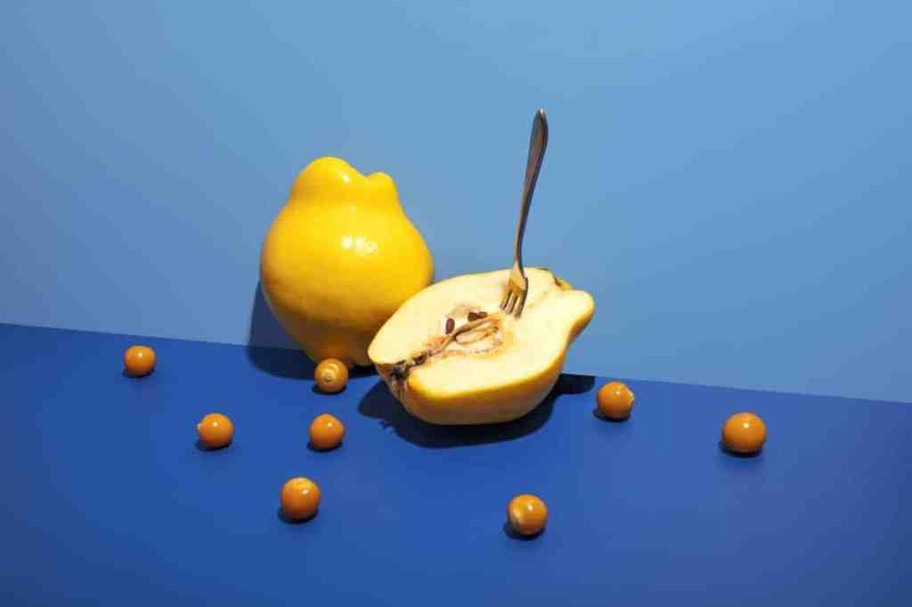 Quince fruit sliced open on a blue background.