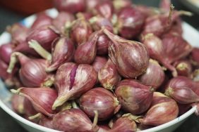 Shallots in bowl with skins on.
