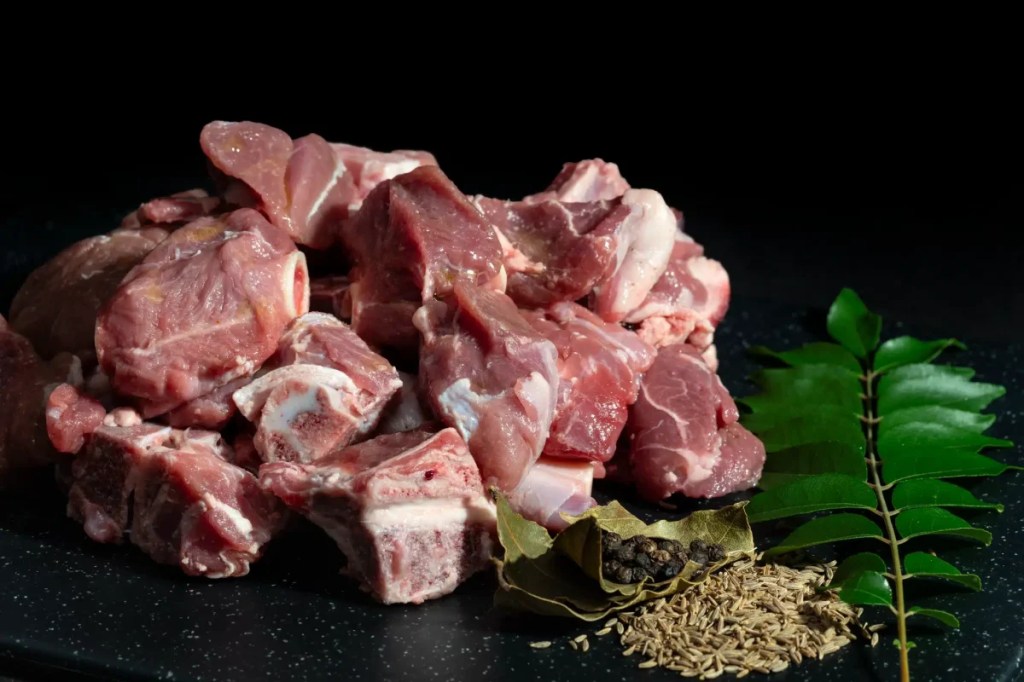 A photograph of sliced goat meat, which dogs can eat safely as long as it's thoroughly cooked.