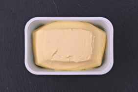 Just opened margarine box on a plate of slate.