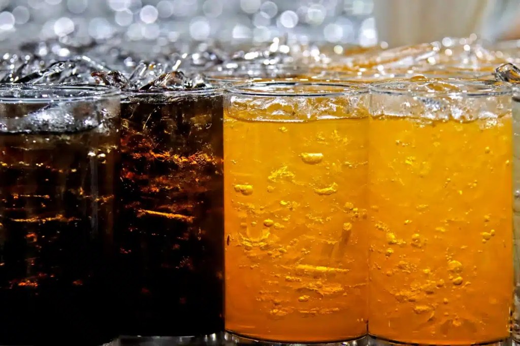 A closeup photo of multiple glasses of refreshing looking soda, which dogs cannot drink and is not safe for them to consume.